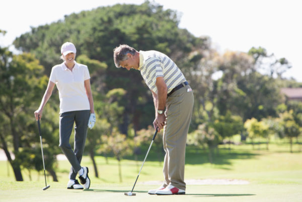 Golfers putting on green